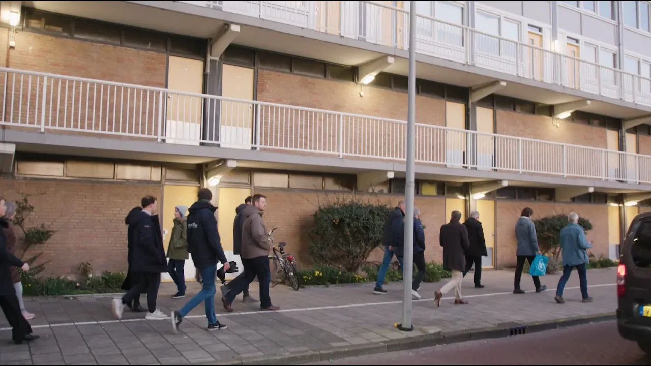 Bewoners lopen samen naar de vve-avond over verduurzamen en optoppen in de metropoolregio Amsterdam.