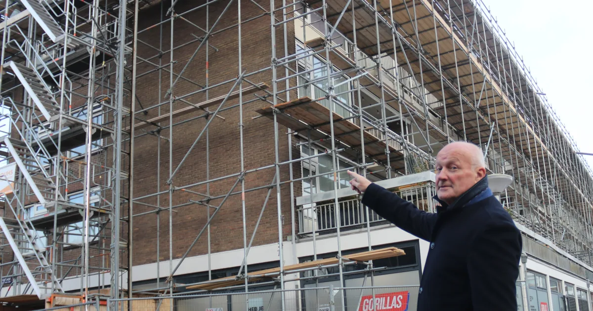 Toelichting bij een gebouw in de steigers tijdens de voorbereiding van een optopproject.