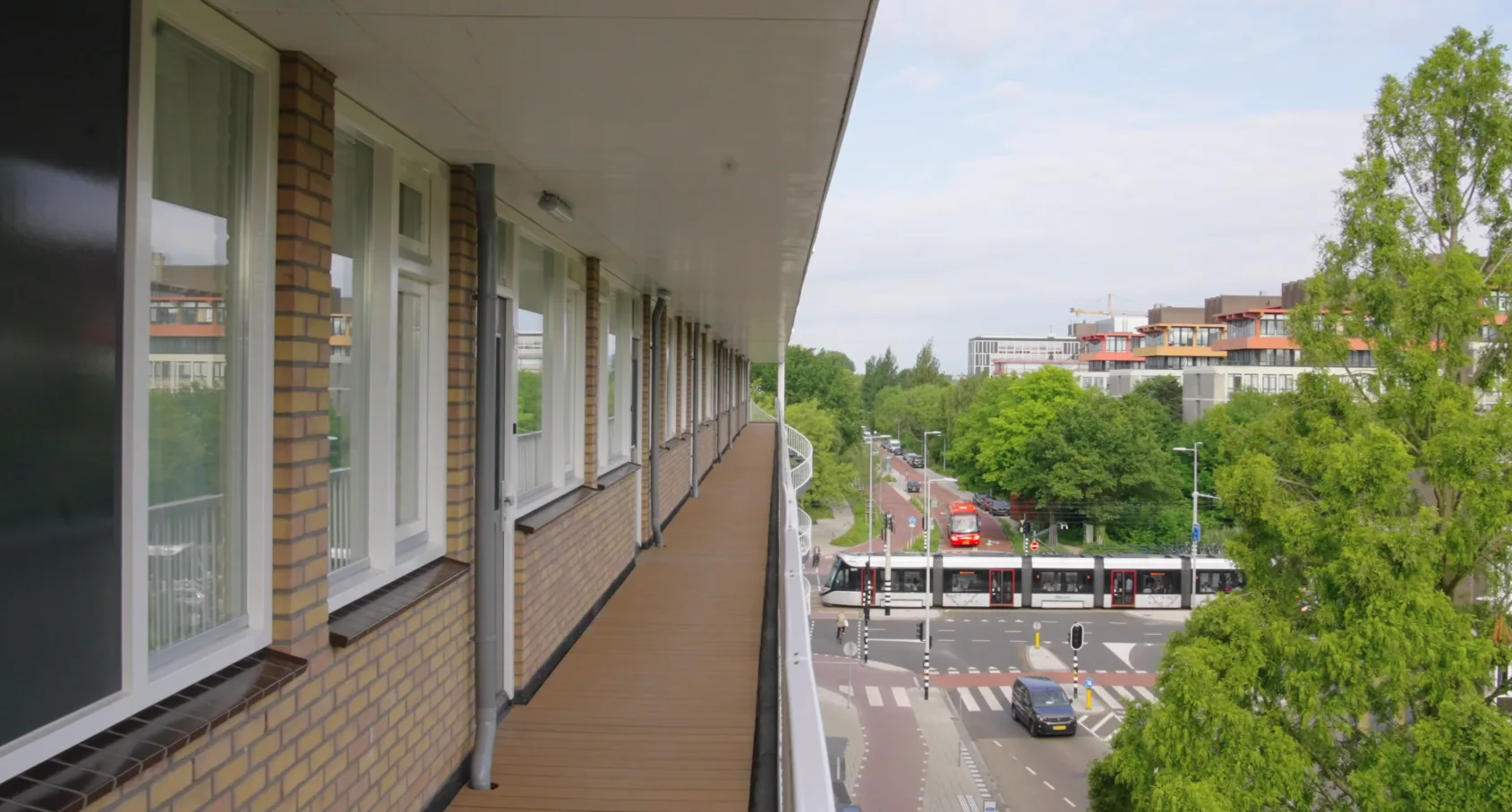 Uitzicht vanaf een nieuwe galerij op de opgetopte verdieping, met de straat en een tram eronder.