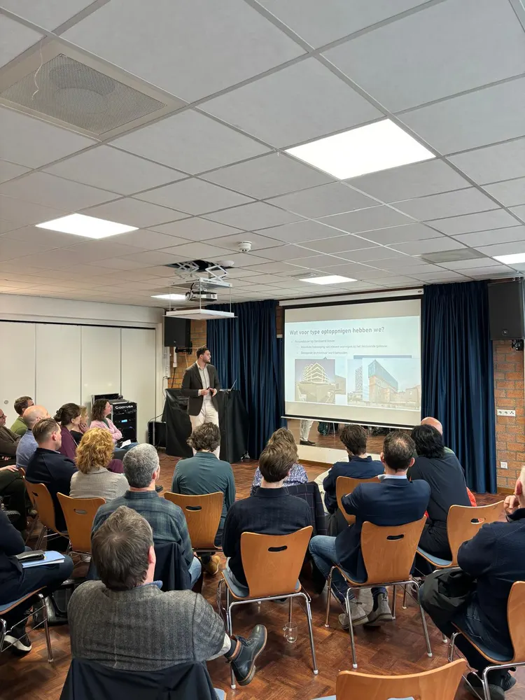 Een volle zaal kijkt naar een presentatie