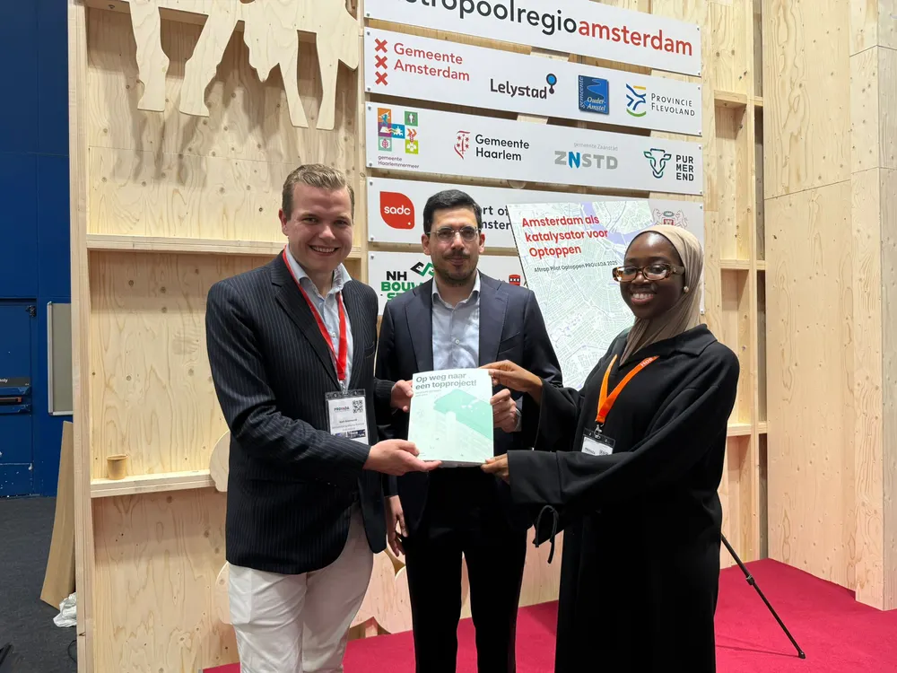 Drie mensen houden samen een rapport omhoog op een evenement