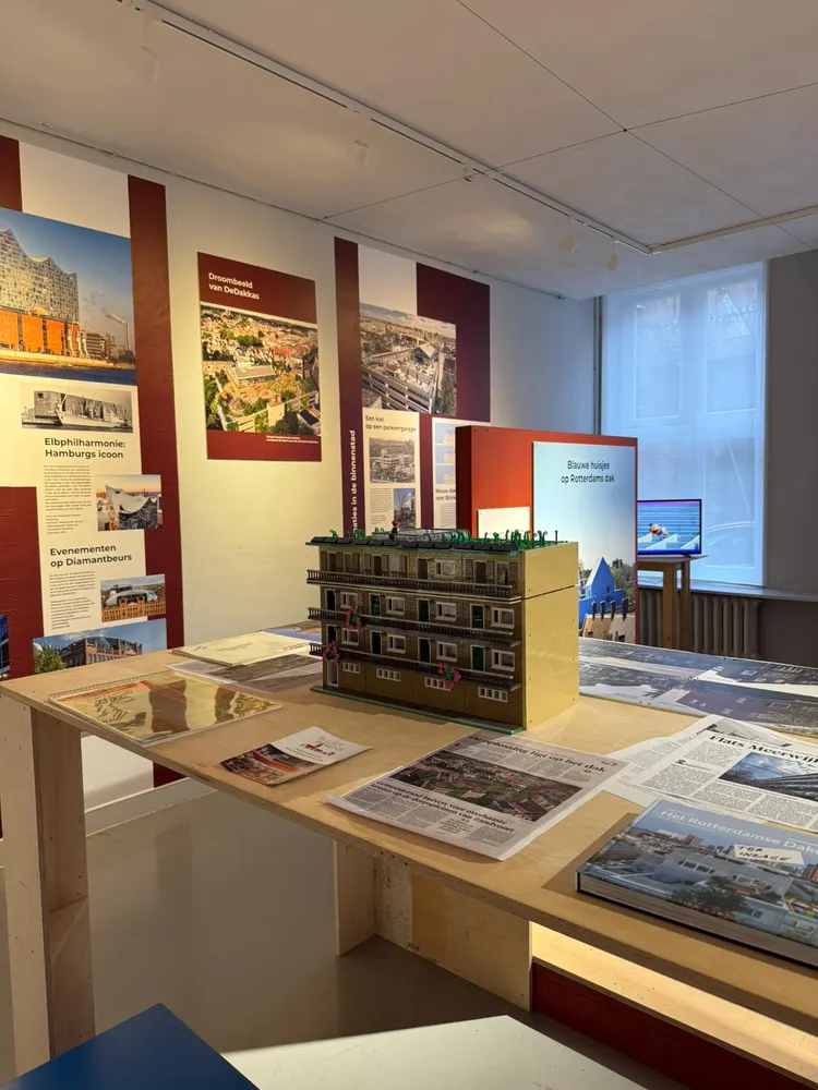 Panelen van een tentoonstelling over optoppen, met een maquette op een sokkel