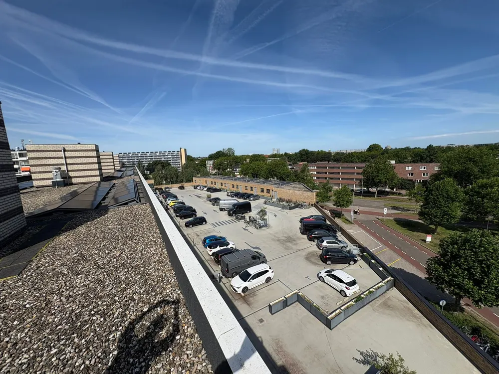 Uitzicht vanaf een dak over de straat en de bomen erachter